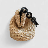 Vista lateral del clutch de rafia natural con detalle de cadena negra