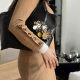 Modelo sosteniendo el Mikado Negro con look urbano chic.