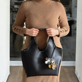 Reflejos metálicos del bolso Mikado sobre fondo neutro.