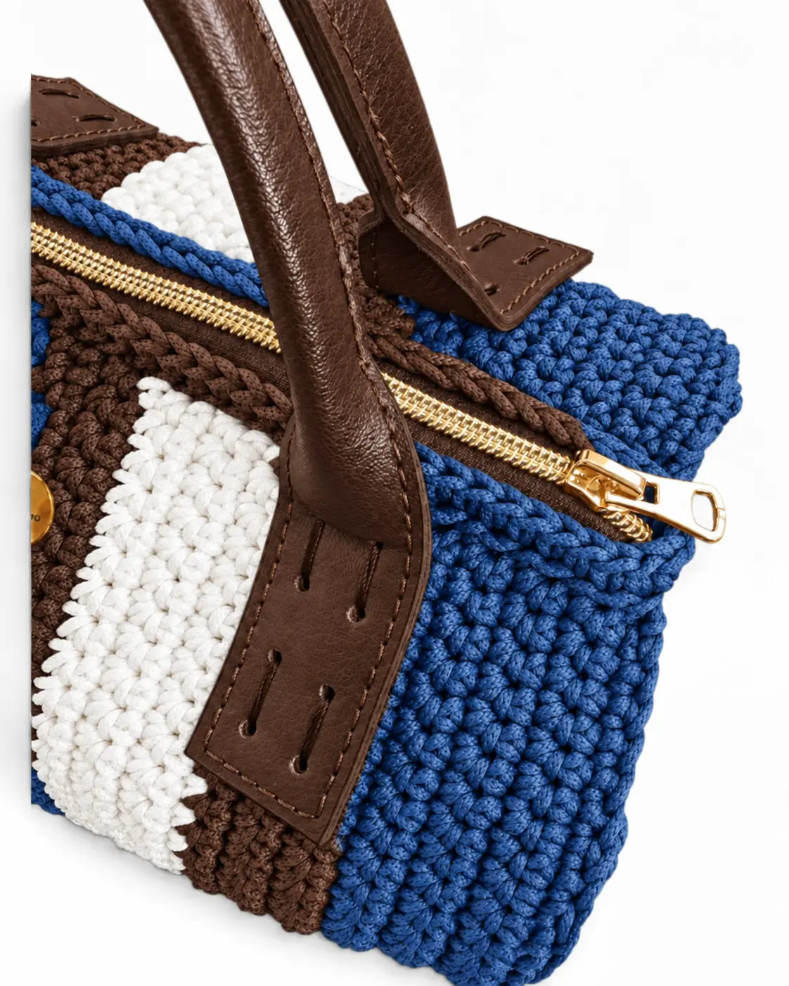 Detalle de la cremallera dorada, el tejido azul denim, marrón y blanco y las asas del Bowling Urbana