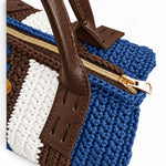 Detalle de la cremallera dorada, el tejido azul denim, marrón y blanco y las asas del Bowling Urbana