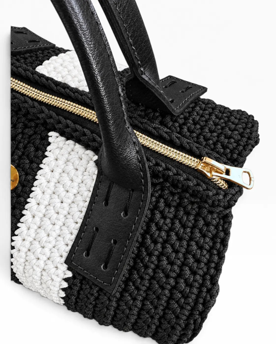 Detalle de la cremallera dorada, el tejido negro y blanco y las asas de ecocuero negro del Bowling Urbana