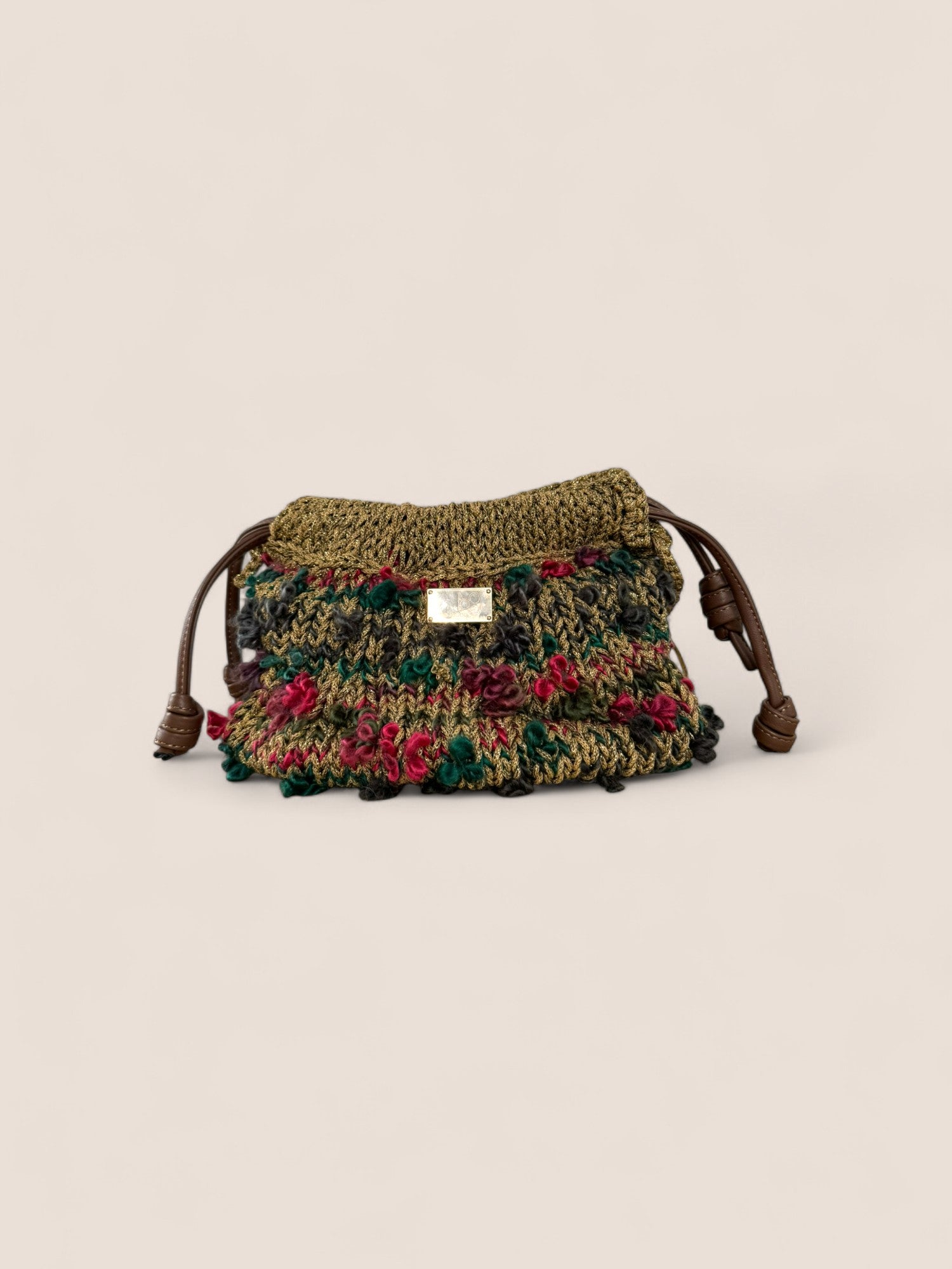 Detalle del bolso scrunch Copenhague Dorado con cierre de cordón en microfibra de cuero y tejido artesanal dorado con textura luminosa