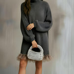 Mujer en cena elegante sosteniendo el Bombón plata bajo luz cálida.