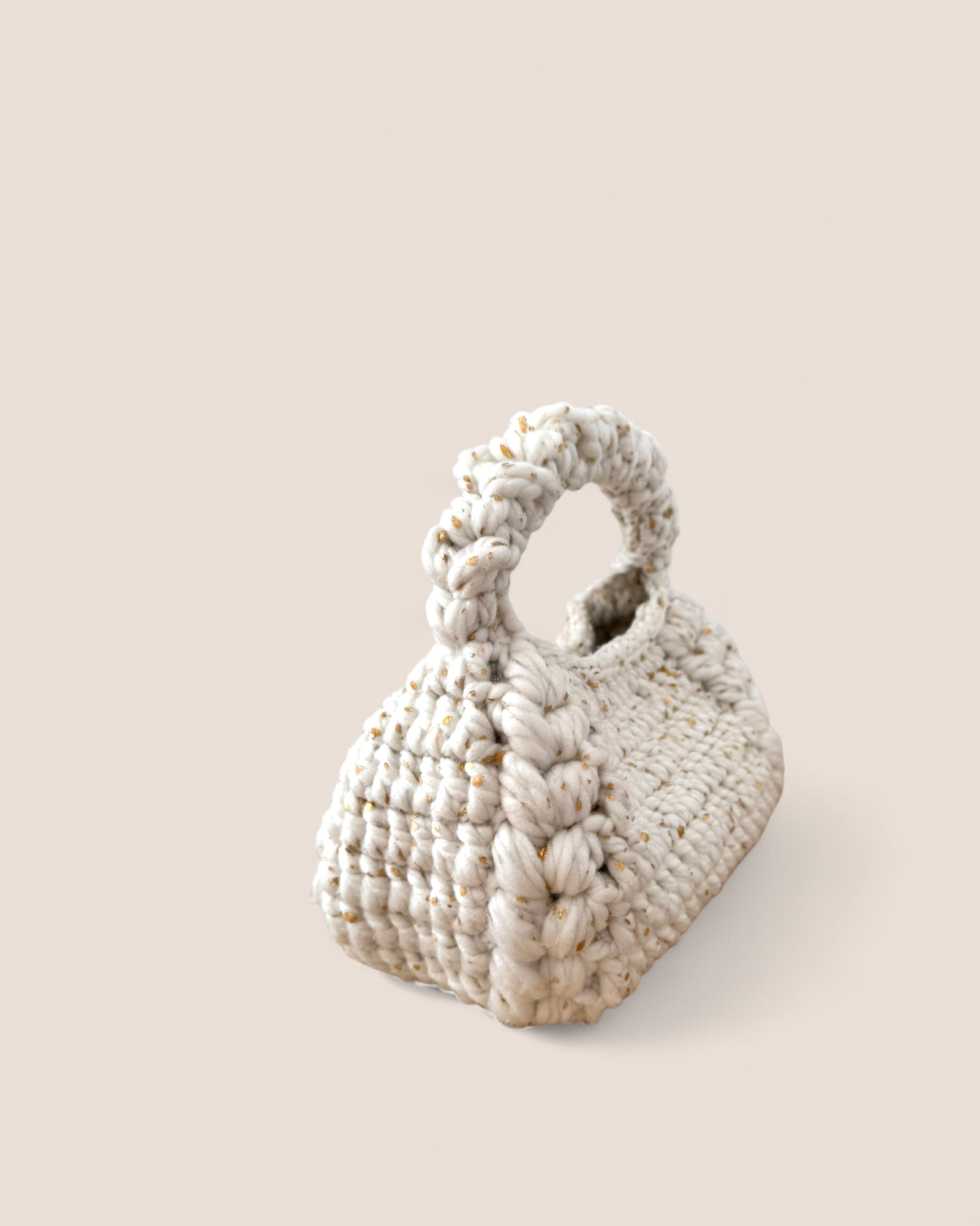 Detalle del tejido grueso con hilos blancos y dorados del bolso Bombón Blanco.