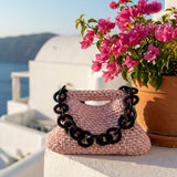 clutch rosa pálido en el alféizar con flores