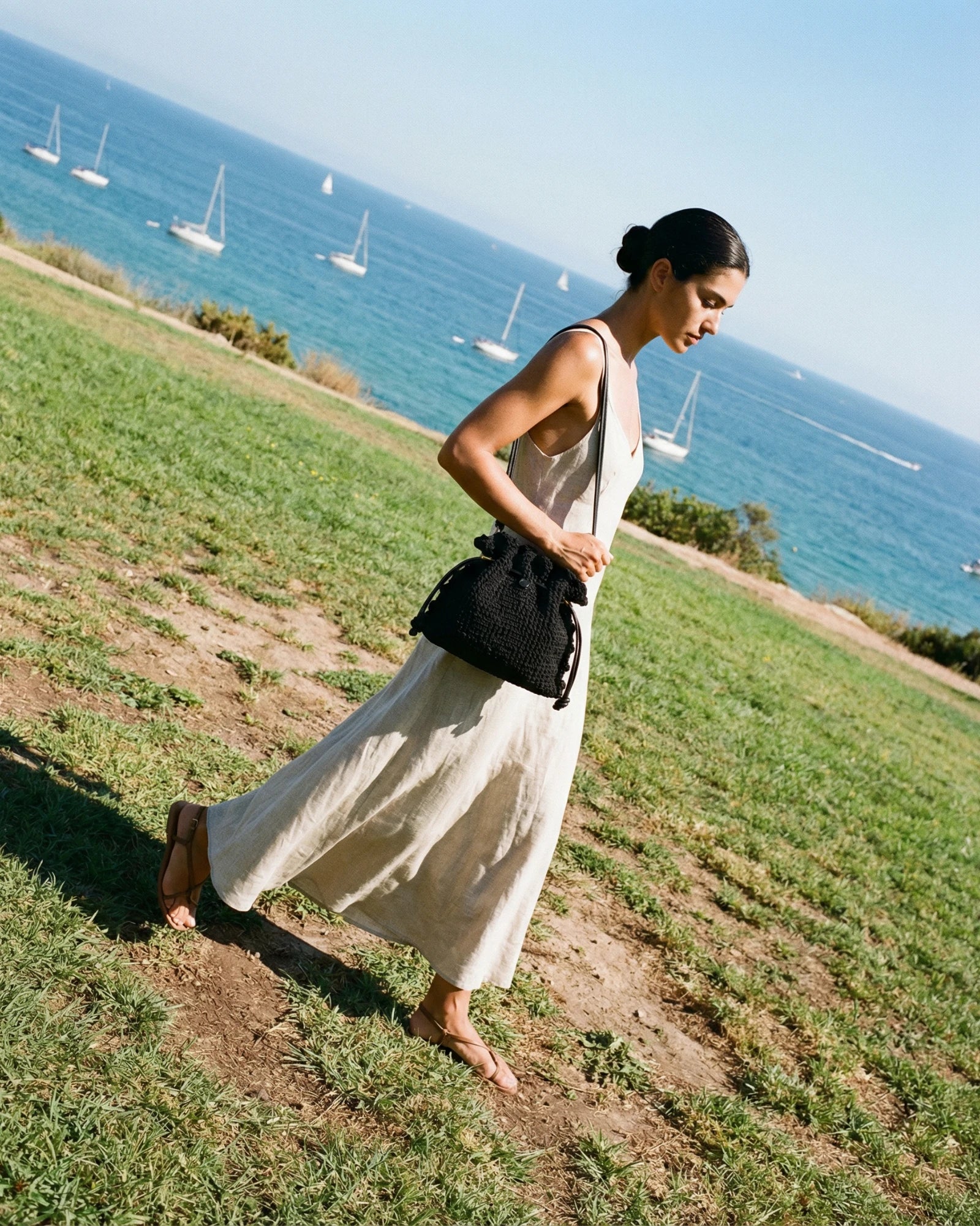 Chica caminando al borde la colina con un bolso copenhague lace negro tejido a crochet