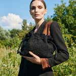 Modelo elegante sosteniendo el bolso copenhague lace negro colección SS2026
