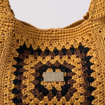 Detalle en zoom del bolso granny mostaza con el logotipo de the labbo impreso sobre latón