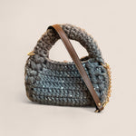 Detalle del bolso bombon con correa de microfibra