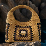 Primer plano del patrón granny square en tonos mostaza, negro y marrón del bolso hecho a mano