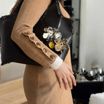 Modelo sosteniendo el Mikado Negro con look urbano chic.