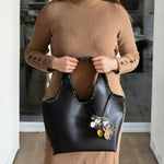 Reflejos metálicos del bolso Mikado sobre fondo neutro.