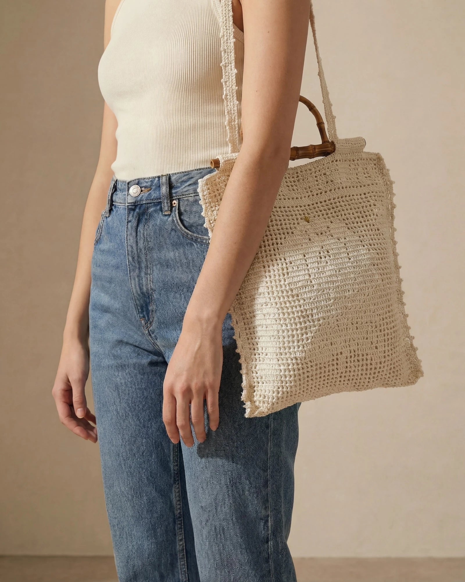 Tote Lace crudo colgado al hombro mostrando su tamaño.