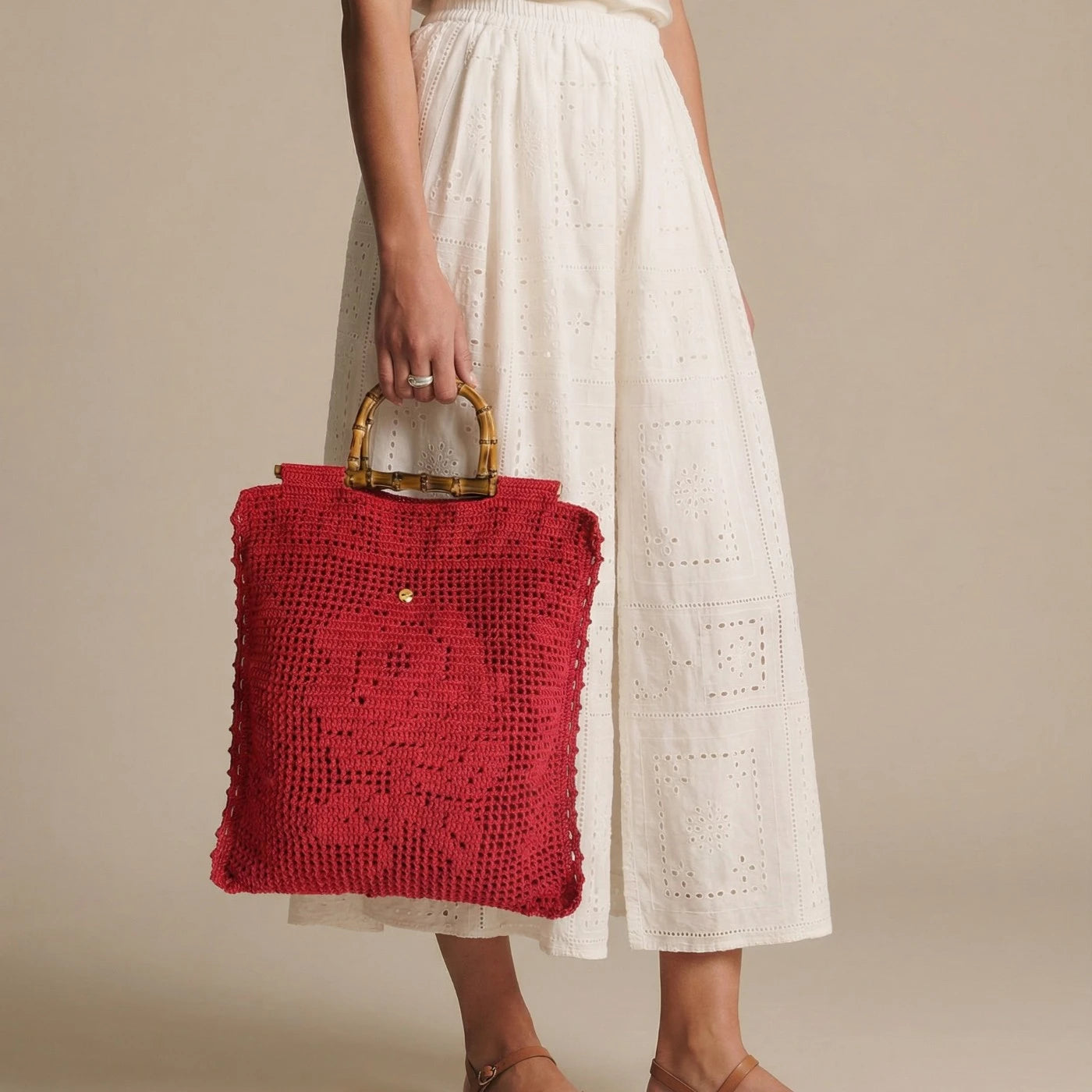 Imagen de tote lace rojo llevado en la mano SS26 The Labbo