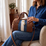 Bolso Bowling Urbana marrón de The Labbo sobre el regazo de una modelo sentada con conjunto vaquero.