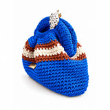 Three-quarter view of Clutch Urbana Blue by The Labbo, showing the folds, stripes and yarn-covered handle in vivid blue, terracotta brown and ecru.