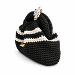 Three-quarter view of Clutch Urbana Black and White by The Labbo, showing the folds, stripes and yarn-covered handle in black and white.