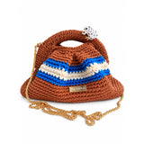 Clutch Urbana de The Labbo en terracota, azul y crudo con cadena de latón bañada en oro sobre fondo blanco.