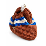 Vista de tres cuartos del Clutch Urbana de The Labbo, con pliegues, franjas azul y crudo y asa tejida en terracota.
