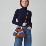 Fashion model turns slightly to the side while lifting the crocheted bag higher on her shoulder, camera pans gently left